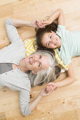Caucasian grandmother and granddaughter laying on floor - BLEF12560