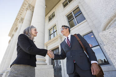 Business people shaking hands courthouse - BLEF12580