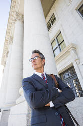 Mixed race businessman standing outside courthouse - BLEF12581