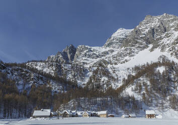 Ländliches Dorf unter verschneiten Bergen - BLEF12703