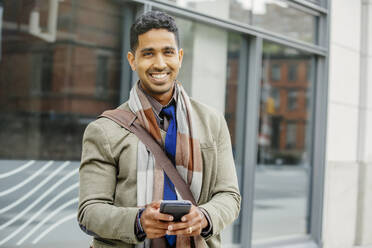 Indischer Mann benutzt Mobiltelefon in der Stadt - BLEF12780