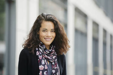 Mixed race woman smiling in city - BLEF12782