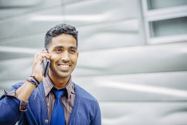 Indian businessman talking on cell phone outdoors - BLEF12795