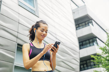 Mixed race athlete listening to mp3 player - BLEF12815