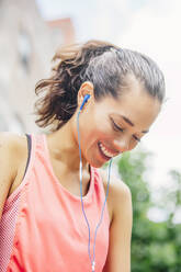 Indian athlete listening to earbuds - BLEF12821