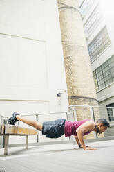 Indian man doing push-ups on bench - BLEF12824