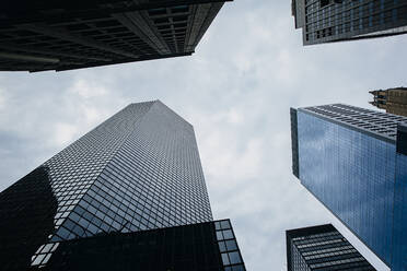 Low angle view of high rise buildings under cloudy sky - BLEF12839