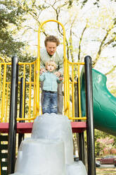 Caucasian father and son playing on play structure - BLEF12932