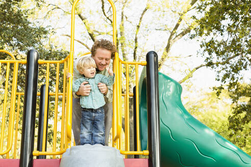 Caucasian father and son playing on play structure - BLEF12933