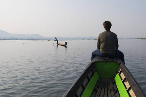 Kaukasischer Mann sitzt auf einem Kanu auf einem ländlichen See - BLEF12955