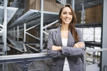 Portrait of smiling businesswoman in a factory - BSZF01170