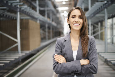 Porträt einer lächelnden Geschäftsfrau in einer Fabrik - BSZF01200