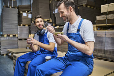 Two happy workers having lunch break in factory - BSZF01212