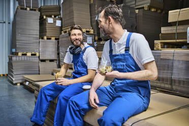 Zwei glückliche Arbeiter in der Mittagspause in einer Fabrik - BSZF01213