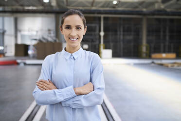 Portrait of smiling businesswoman in a factory - BSZF01221