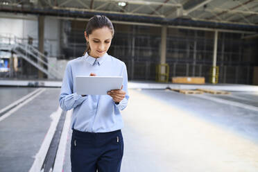 Businesswoman using tablet in a factory - BSZF01227