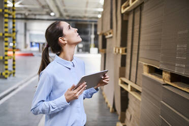 Businesswoman with tablet in a factory warehouse checking stock - BSZF01229