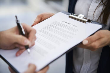 Close-up of employee signing employment contract - BSZF01270