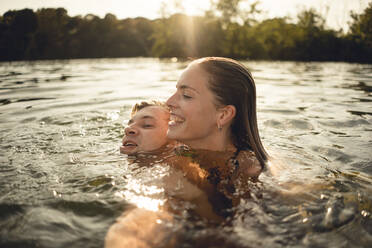 Affectionate couple swimming together in a lake - GUSF02305