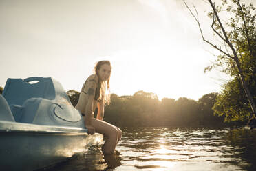 Young woman relaxing on the lake, sitting on boat - GUSF02311