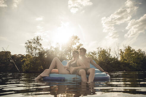 Young couple sitting on a boat on the lake, relaxing - GUSF02343