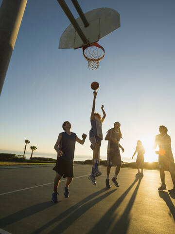 Von hinten beleuchtete Basketballteams auf dem Spielfeld, lizenzfreies Stockfoto