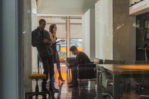 Geschäftsleute stehen in der Büro-Lobby, lizenzfreies Stockfoto