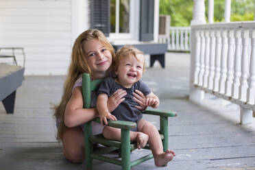 Kaukasisches Mädchen und Kleinkind Bruder spielen auf Veranda - BLEF13012
