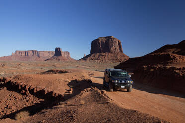 Autofahrt auf abgelegener Straße durch Felsformationen, Monument Valley Tribal Park, Utah, Vereinigte Staaten - BLEF13081