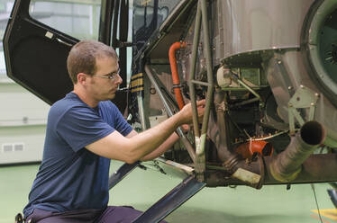 Spanischer Mechaniker arbeitet an einem Hubschrauber im Hangar - BLEF13111