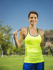 Mixed race woman holding jump rope in park - BLEF13120
