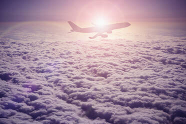 Silhouette eines Flugzeugs, das über Wolken fliegt - BLEF13219