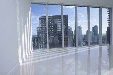 Fenster mit Blick auf die Stadtlandschaft in einer leeren modernen Wohnung - BLEF13242