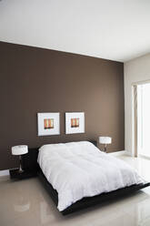 Wandkunst, Lampen und Bett in einem modernen Schlafzimmer - BLEF13244