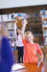 Student raising her hand in library - BLEF13292