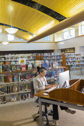 Hispanische Frau am Computer in der Bibliothek - BLEF13309