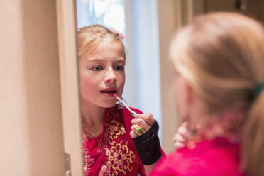 Kaukasisches Mädchen trägt Lipgloss im Spiegel auf - BLEF13338