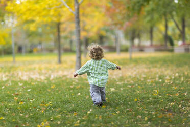 Caucasian boy running on grass lawn - BLEF13343