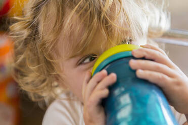 Kaukasisches Baby trinkt Wasser aus einer Tasse - BLEF13366