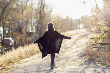 Older Hispanic woman walking on dirt path - BLEF13372