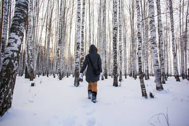 Kaukasische Frau geht im verschneiten Wald spazieren - BLEF13390