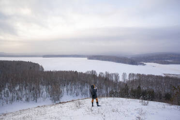 Caucasian woman standing on snowy hilltop - BLEF13393