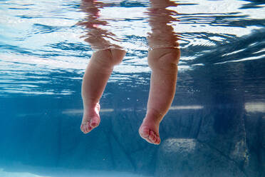 Nahaufnahme der Beine eines unter Wasser getauchten Babys - BLEF13436