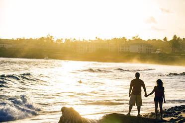 Couple holding hands near ocean on beach - BLEF13440