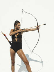 Mixed race woman aiming bow and arrow - BLEF13455