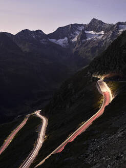 Hohe Winkelansicht von Lichtspuren auf einem Bergpass gegen den Himmel in der Abenddämmerung, Südtirol, Italien - CVF01427