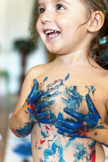 Glückliches Kleinkind, das mit Fingerfarben spielt - GEMF03030