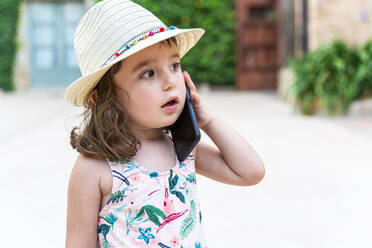 Porträt eines kleinen Mädchens mit Strohhut am Telefon - GEMF03032