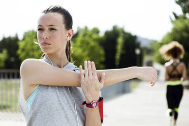 Sporty teenage girl doing stretching exercise - JSRF00471