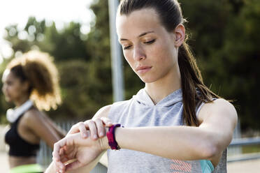 Sporty teenage girl checking her smartwatch - JSRF00489